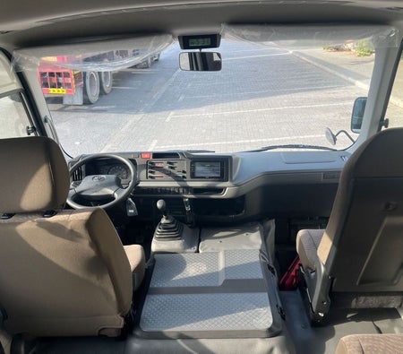 White Toyota Coaster 2025