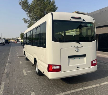 White Toyota Coaster 2025