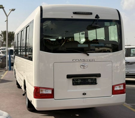 White Toyota Coaster 2025