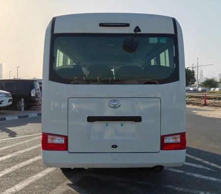 White Toyota Coaster 2026