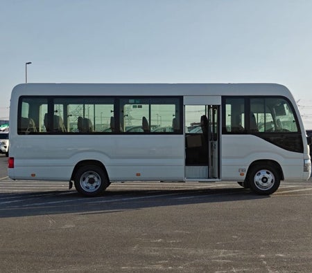 White Toyota Coaster 2026