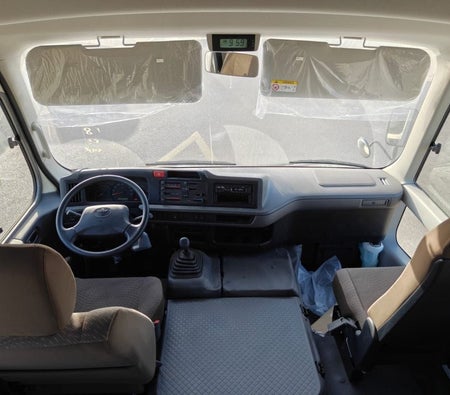 White Toyota Coaster 2026